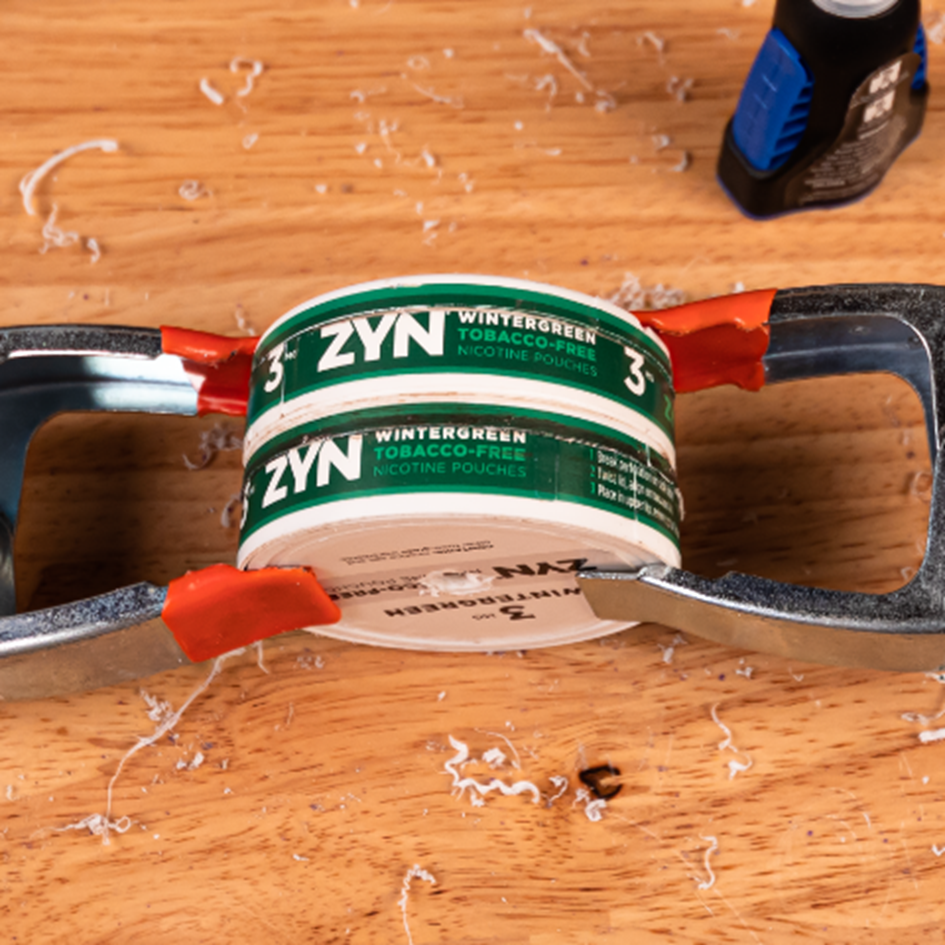 Two ZYN wintergreen cans glued together on a wooden table.