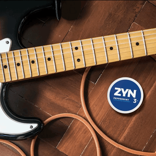 A can of peppermint ZYN sitting on an electric guitar. 