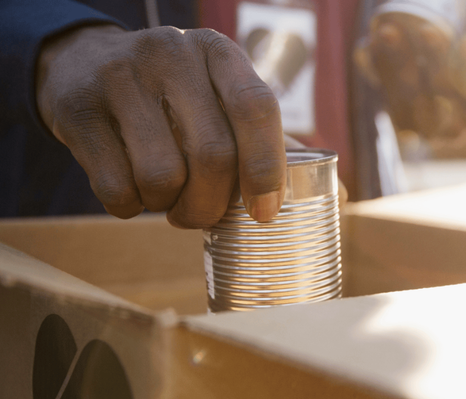 Hand Putting a Can in a Box